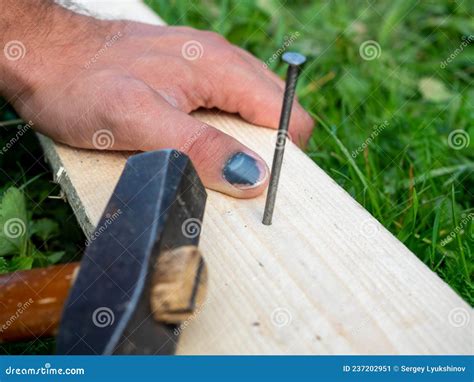 The Man Was Hammering A Nail Into The Board But Hit On The Finger Of