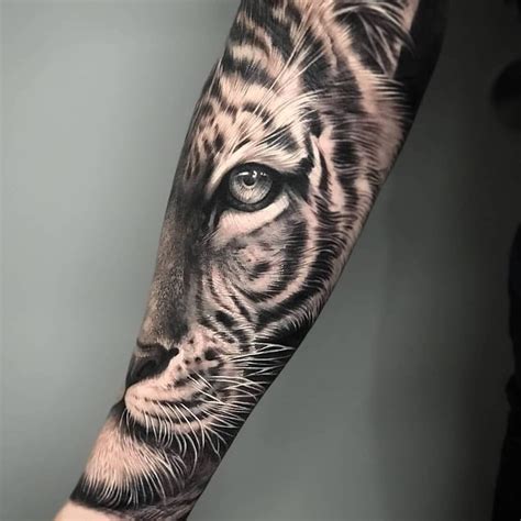 A Black And White Tiger Tattoo On The Left Arm With An Eye Looking