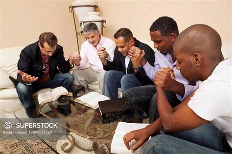 A Group Of Men Praying Together Superstock