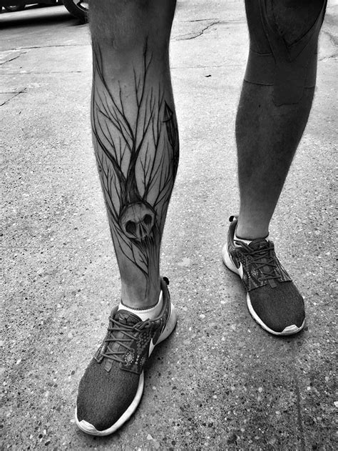 horror style black ink leg tattoo of human skull with tree by inez janiak tattooimages