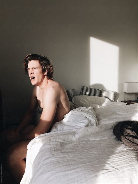 Man Yawning In Bed In The Morning Sun Del Colaborador De Stocksy Katie Joe Stocksy