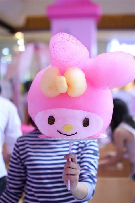 A Woman Holding Up A Pink Stuffed Animal With A Bow On Its Head