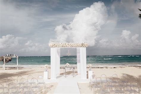 All White Beach Wedding Ceremony With Ghost Chairs And A Beautiful Top