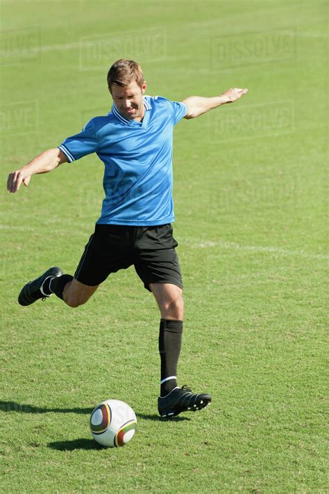 Soccer Player Kicking Soccer Ball On Soccer Field Stock Photo Dissolve
