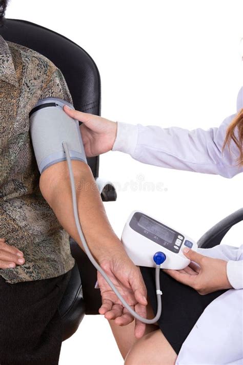 Female Doctor Measuring Blood Pressure Of Senior Woman Stock Image