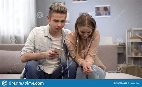 Teen Couple Listening To Music Together Shy To Communicate On First
