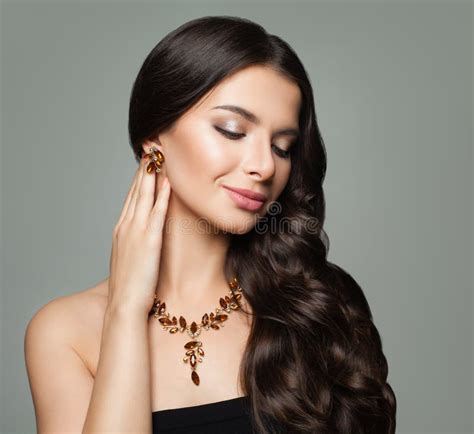 Brunette Girl With Makeup Healthy Curly Hair Gold Jewelry Necklace And Earrings With Amber