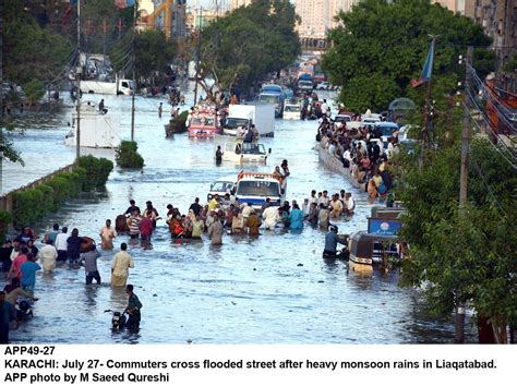 Karachi July 27 Commuters Cross Flooded Street After Heavy Monsoon