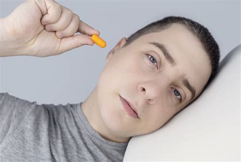 The Man Puts On Earplugs Closeup Of An Orange Noise Barrier Deep Sleep