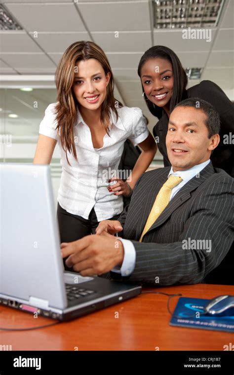 Three Business People Gathered In Front Of A Laptop At The Office With