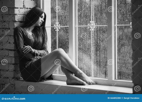Piękna Młoda Kobieta Siedzi Samotnie Blisko Do Okno Z Podeszczowymi