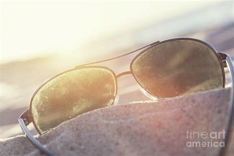 Sunglasses On Sand At Sunset Beach And Ocean In The Background