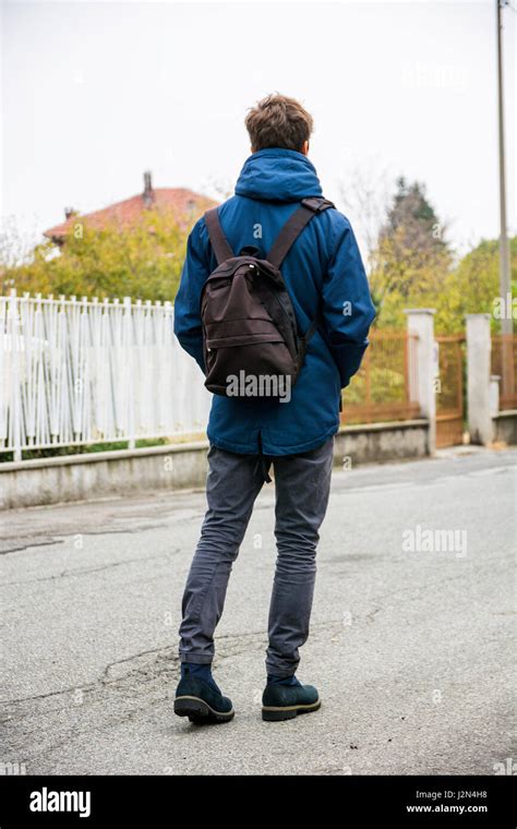 Teenage Boy Walking Alone In Street With Backpack Stock Photo Alamy