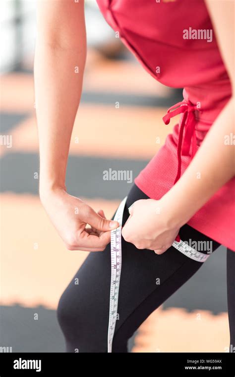 Midsection Of Woman Measuring Thigh With Tape Measure Stock Photo Alamy