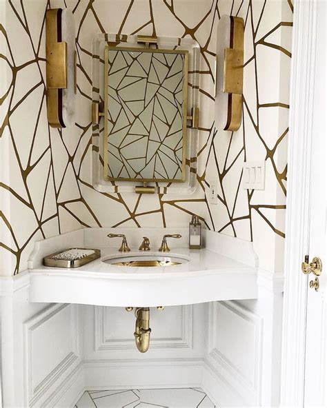 A White Bathroom With Gold Leaf Wallpaper And Marble Flooring Along