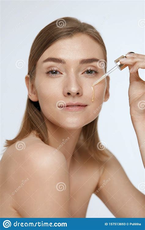 Skin Care Woman Applying Serum Or Facial Oil On Beauty Face Stock