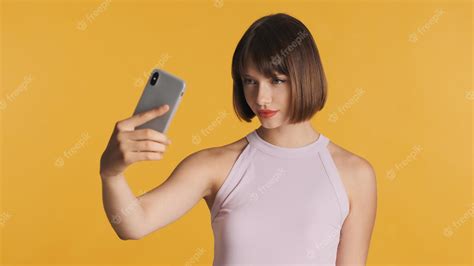 premium photo beautiful brunette girl with bob hair and red lips making selfie on smartphone