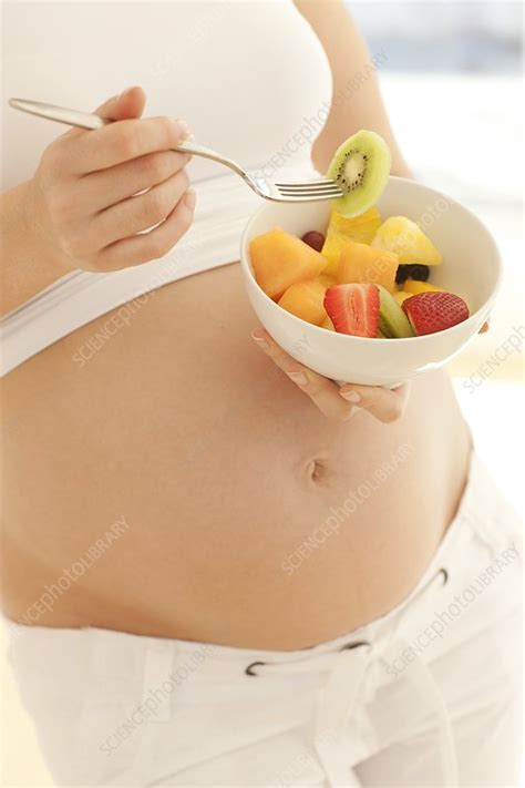 Pregnant woman eating a fruit salad - Stock Image - F004/0619 - Science