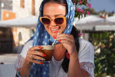 Happy Young Woman Drinking Iced Coffee In Restaurant Stock Photo