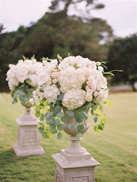 White Floral Arrangements On Stone Pedestals For A Classic Southern