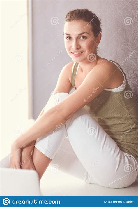 Attractive Caucasian Girl Sitting On Floor With Cup And Tablet Near Wall Stock Image Image Of