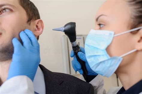Close Up Photo Of A Female Otolaryngologist Examining The Ear Stock