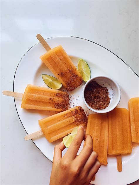 A Plate With Popsicles Limes And Spices On Them Next To A Small Bowl