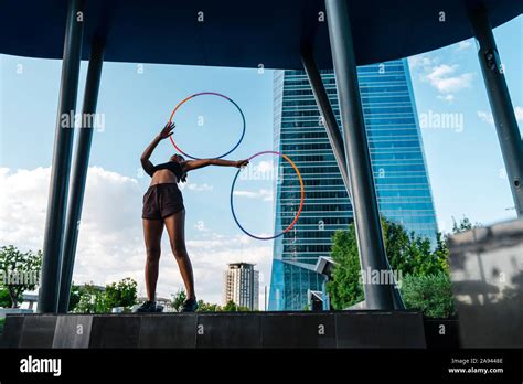 Generation Z Woman Performing Hula Hoop Dance With Rings In Downtown