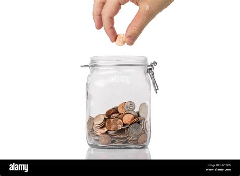 Penny Pinching or saving concept - a jar of American coins with a hand