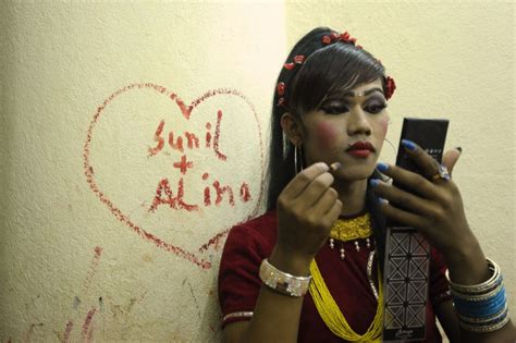 a nepalese transgendered performer puts on make up backstage
