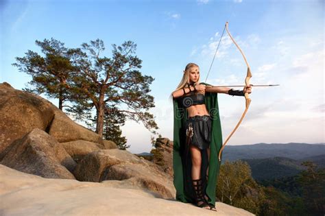 Beautiful Female Elf Archer In The Forest Hunting With A Bow Stock