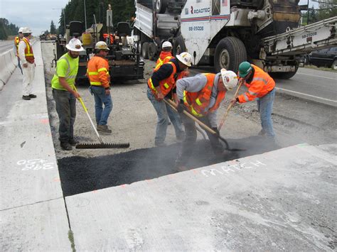 Laying asphalt first | Crews lay the base layer of asphalt ...