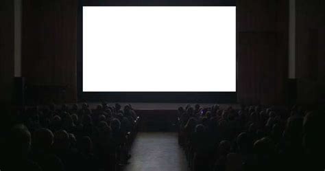 Back View Of Audience In Dark Cinema Hall In Front Of Big Blank Screen