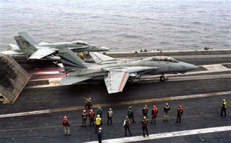 Flight Deck Personnel Watch As An F 14 Tomcat Hits The Afterburner