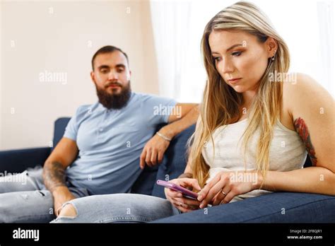 Suspicious Man Looking At His Girlfriends Smartphone Screen While They