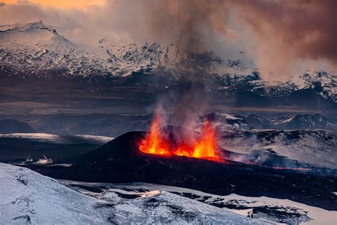 Fire Fountains From Two Erupting Craters Enveloped By Snowy Mountains