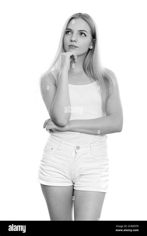 Studio Shot Of Young Beautiful Teenage Girl Standing While Thinking