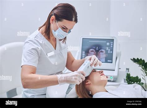 Charming Beautician In Medicine Uniform Taking Skin Care With Modern