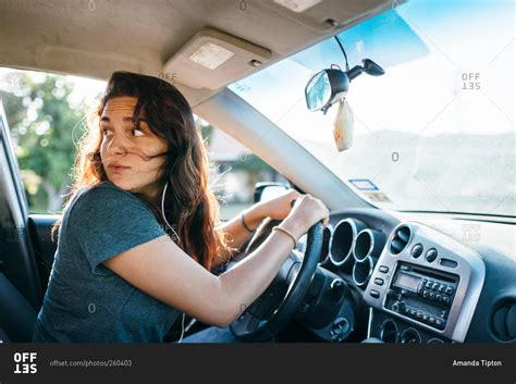 Teenage Girl Behind The Wheel Looks Behind Her As Shes Driving Stock