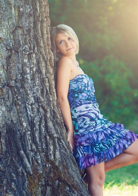 Portrait Of Fashionable Young Sensual Blonde Woman In Garden Lean On The Tree Stock Image