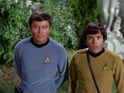 Two Men Standing Next To Each Other Wearing Star Trek Uniforms