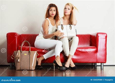 Two Women Sitting On Sofa Presenting Bag Stock Photo Image Of Sitting Fashionable