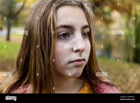 Close Up Of A Teenage Blonde Girl Looking Sad Outside In The Fall