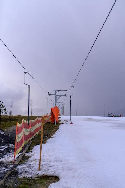 Premium Photo A Snow Covered Ski Lift With A Orange Fence In The