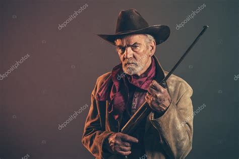 Old Rough Western Cowboy With Gray Beard And Brown Hat Holding R Stock