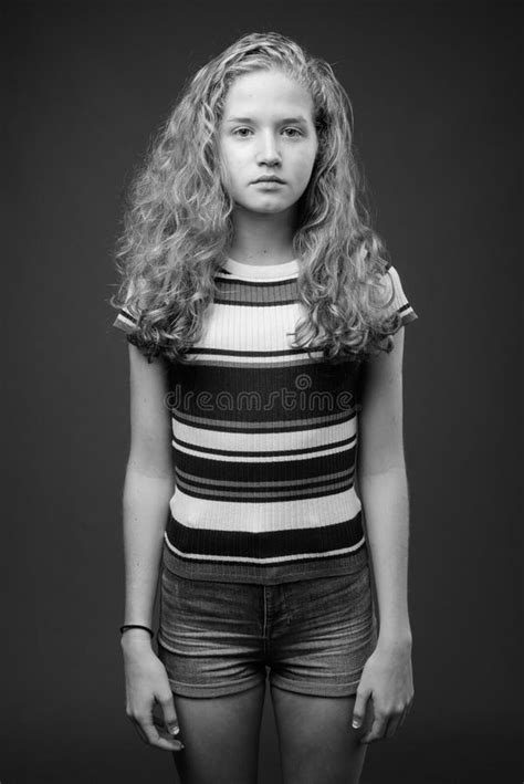 Young Beautiful Blonde Teenage Girl Smiling Against Brown Background