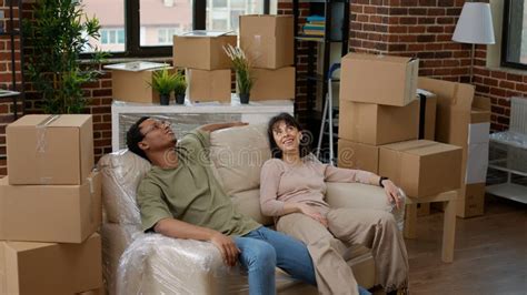 Tired Husband And Wife Relaxing On Couch After Unpacking Furniture Stock Image Image Of