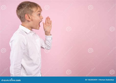 Profile Of Young Handsome Kid Shouting Studio Portrait Over Pink