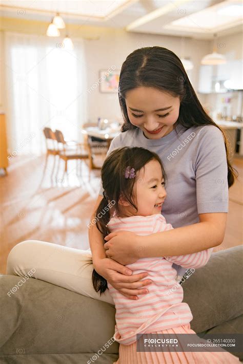 Beautiful Happy Asian Mother And Daughter Hugging At Home Together My