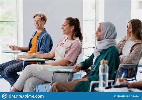 Group Of Multiethnic University Students Sitting In Classroom Indoors